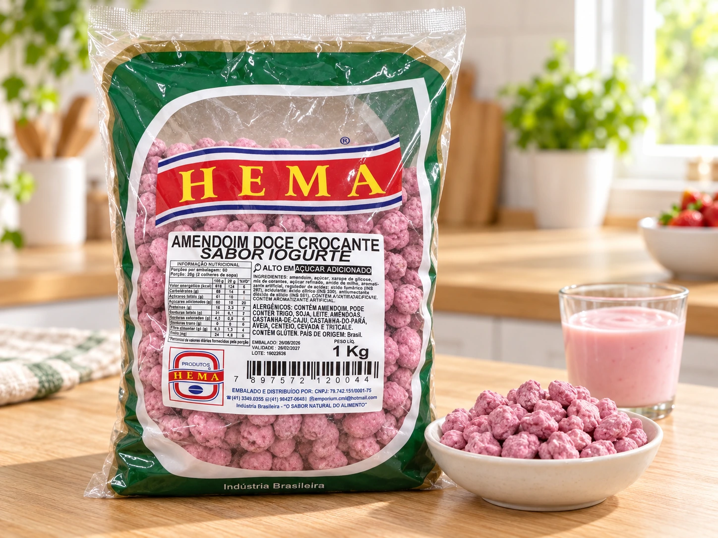 Pacote HEMA de 1 kg de amendoim doce crocante sabor iogurte, cor rosa, com tigela do produto solto ao lado, em bancada de madeira