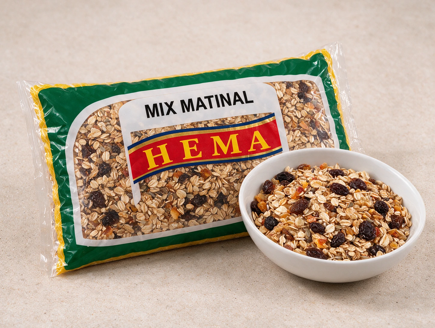 Pacote Hema de mix matinal e müsli ao lado de tigela branca com a mistura de flocos, frutas secas e sementes servida